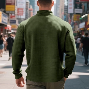 Outdoor street view showing the back detail of an olive green waffle knit sweatshirt