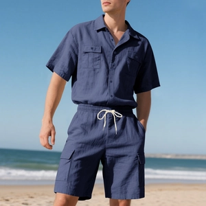 Detail eines dunkelblauen Leinenhemdes mit Brusttaschen und passenden Cargo-Shorts am Strand
