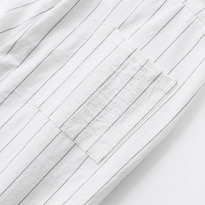 Macro shot of fine black vertical stripes on white linen fabric with a square pocket detail