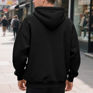 Detail view of black hoodie back with elastic ribbed hem in an urban street setting
