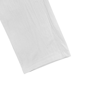 Detail view of white linen trousers showing professional stitching and fabric texture