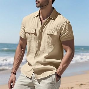 Detail shot of a men's linen short sleeve shirt with flap pockets at a sunny beach