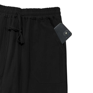 Detail view of elastic waist with drawstring and deep side pocket on linen pants