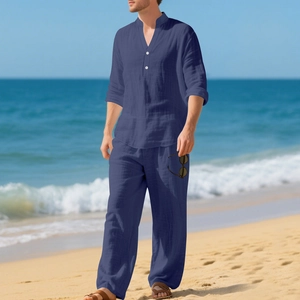 Dettaglio completo di camicia henley e pantaloni in lino blu scuro sulla spiaggia