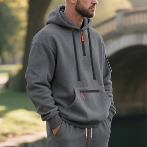 Detail of grey men's hoodie featuring orange zipper puller and side view of soft fleece