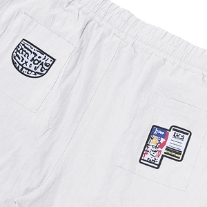 Detail of white linen pants featuring elastic waistband and streetwear style back pockets