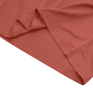 Gros plan sur la double couture et l'ourlet du polo en maille rouge rouille