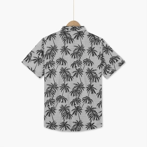 Detail of grey short sleeve shirt featuring black palm tree prints and linen texture