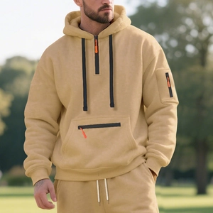 Detail of light beige fleece hoodie with half-zipper collar and orange puller accent