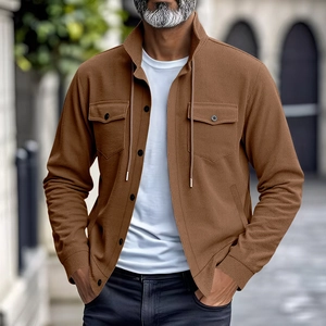 Detail der Textur einer braunen Herren-Cordjacke mit geknöpften Brusttaschen und Kordelzug