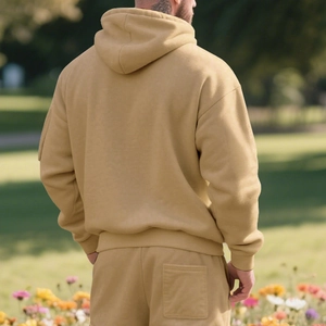 Outdoor back view of a men's mustard yellow fleece hoodie suit with casual dropped shoulders