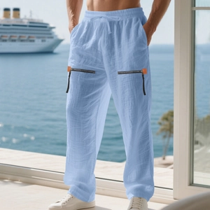 Detail of light blue linen trousers showing elastic drawstring waist and metal zippers