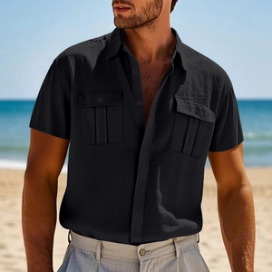 Close-up of black linen short sleeve shirt with flap pockets on a sunny beach setting