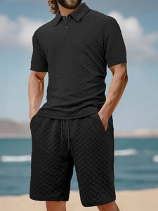 Close-up of black men's knit polo set showing textured V-shape jacquard fabric detail
