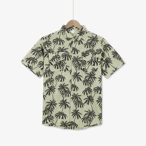 Close-up of tropical palm tree print and button-down chest pockets on men's beach shirt