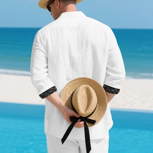 Men's white linen resort shirt detail showing sleeve cuffs with black wave pattern lining