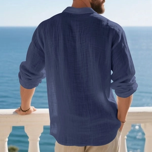 Rear view of a dark blue linen long sleeve polo shirt for men on a scenic seaside balcony