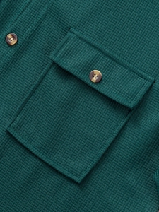 Detailed close-up of green waffle texture shirt with flap pocket and marble button