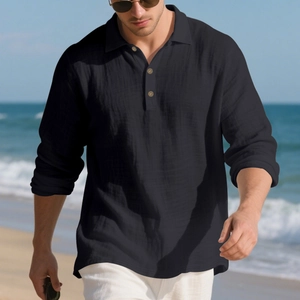 Close-up of black linen long sleeve polo shirt with wooden buttons in a beach setting