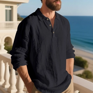 Detail of black linen polo shirt with three-button placket on a sunlit beach terrace