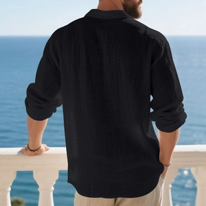 Detailed texture of black linen long sleeve polo shirt on a male model at seaside