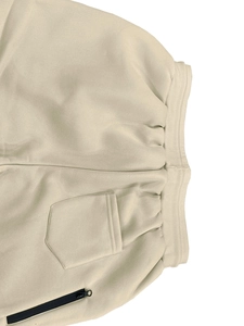 Detail of men's fleece joggers featuring a ribbed waistband and secure zipper pocket