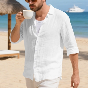 Detail van wit linnen strandhemd met getextureerde stof en casual opgerolde mouwen