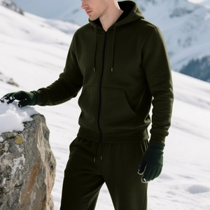 Close-up of olive green fleece hoodie and joggers suit with matching winter gloves in snow