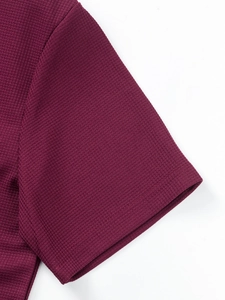 Close-up of waffle texture and neat stitching on wine red men's short sleeve shirt cuff