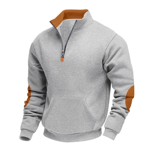 Detail van grijze fleece sweater met oranje elleboogpatches en kwart rits voor herenmode