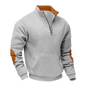 Gedetailleerde close-up van contrasterende oranje elleboogstukken op een grijze hoodie