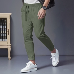 Détail du jogging slim vert olive avec taille à cordon et plis marqués sur la jambe