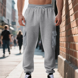 Detailed view of grey quilted jogger pants featuring cargo pockets and drawstring waist