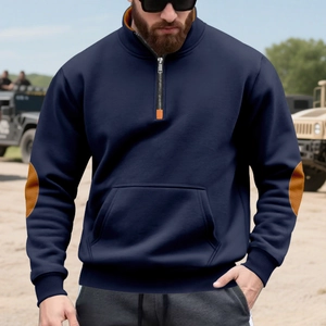 Detail van oranje elleboogstukken op een marineblauwe herensweatshirt met een halve ritssluiting