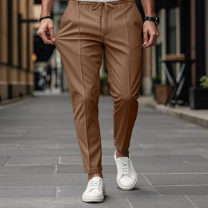Dettaglio dei pantaloni marroni uomo slim-fit con coulisse in vita e pieghe verticali