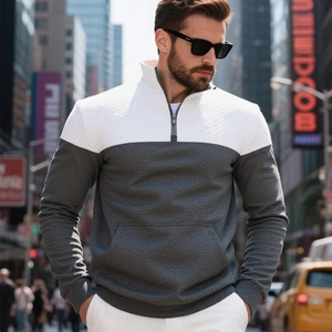Dettaglio del maglione bicolore grigio e bianco con mezza zip e trama a rombi trapuntati