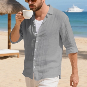 Detail van grijs linnen strandshirt met verticale textuur en witte knopen op het strand