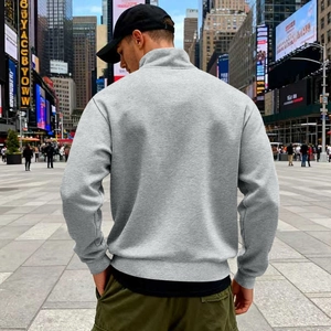 Rear view of grey men's half-zip fleece sweatshirt in urban streetwear setting