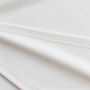Vue détaillée des coutures intérieures du polo blanc et texture des poignets côtelés