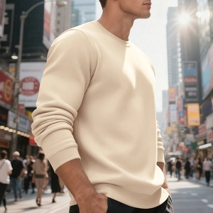Nahaufnahme des beigen Crewneck-Sweatshirts mit Rippbündchen in urbaner Umgebung