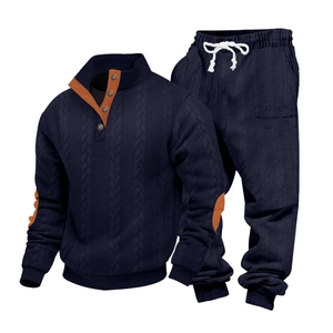 Detail van marineblauwe kabelgebreide sweater met bruine elleboogstukken