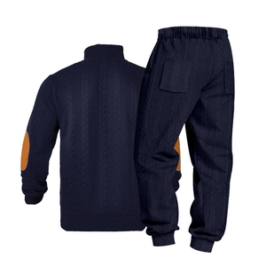 Detail van de marineblauwe gebreide set met bruine elleboogstukken en kabelpatroon