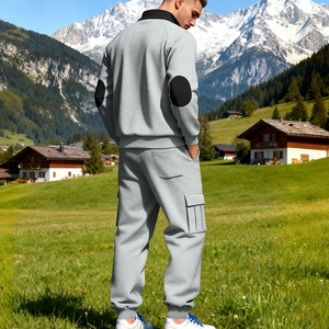 Herren Trainingsanzug in Grau mit schwarzen Ellbogen-Patches und Cargotaschen vor Schneestürmen
