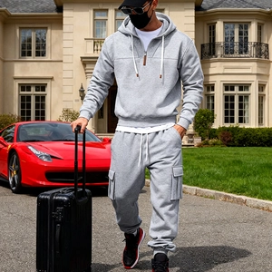 Men's grey half-zip hooded fleece tracksuit with cargo jogger pants in a luxury setting