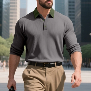Détail d'un polo en maille côtelée gris foncé avec col et boutons vert olive contrastés
