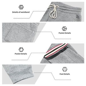 Détail de la taille à cordon, des poches et des poignets rayés du pantalon de jogging gris