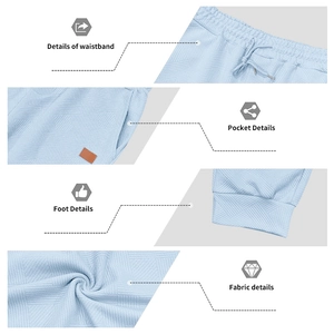 Detail of light blue joggers featuring geometric knit texture and elastic drawstring waist