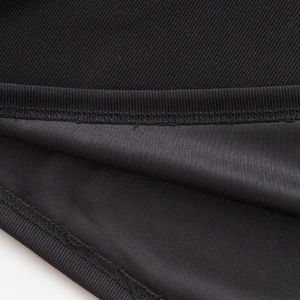 Gros plan du tissu polo noir montrant la texture côtelée et les coutures de haute qualité