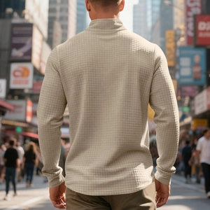 Dettaglio della trama a nido d'ape sulla felpa beige con mezza zip da uomo in città