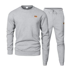 Close-up of men grey tracksuit featuring diamond texture and brown leather patch details